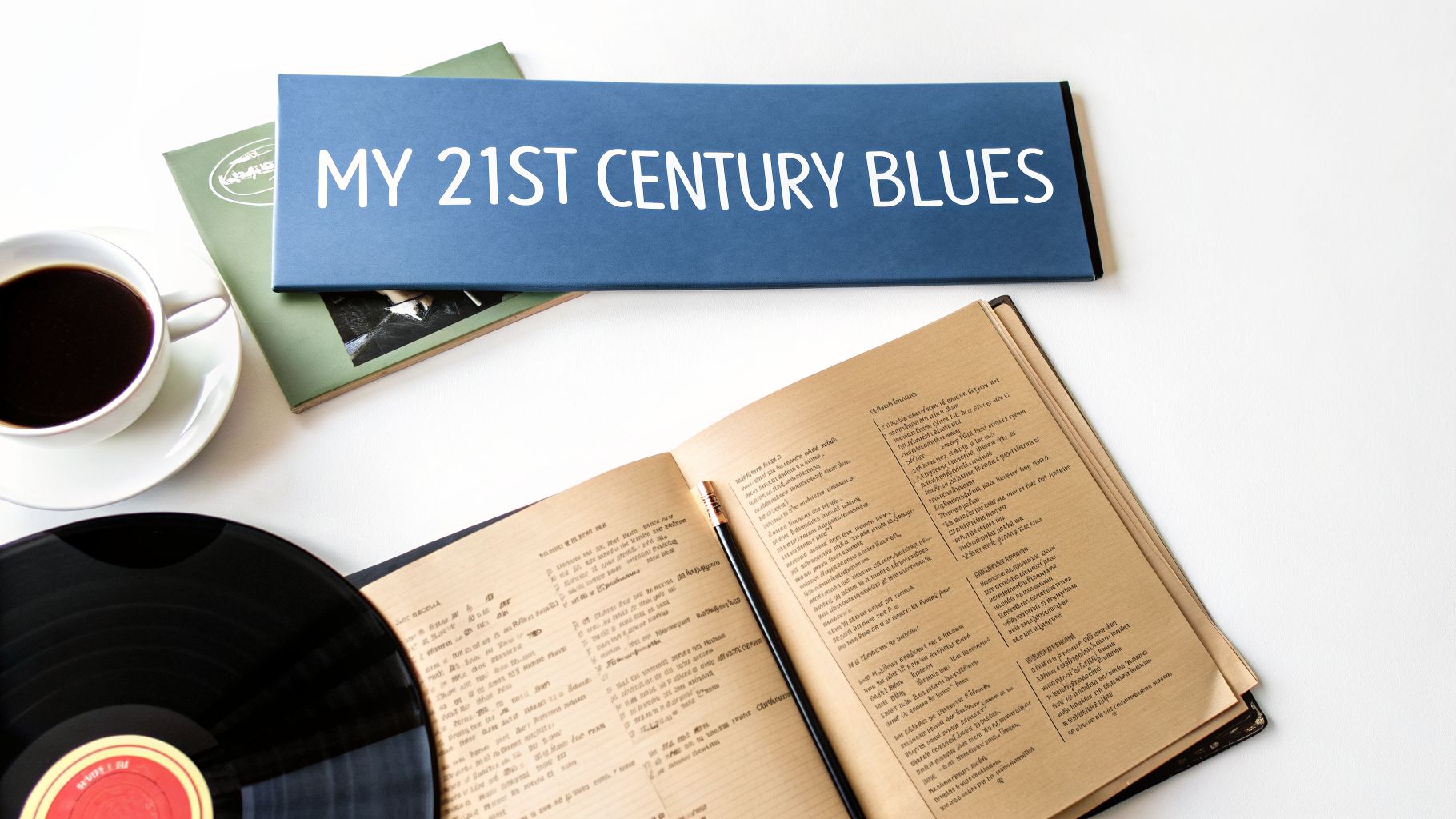 Flat lay of 'MY 21ST CENTURY BLUES' album cover, vinyl record, coffee cup, and an open book.